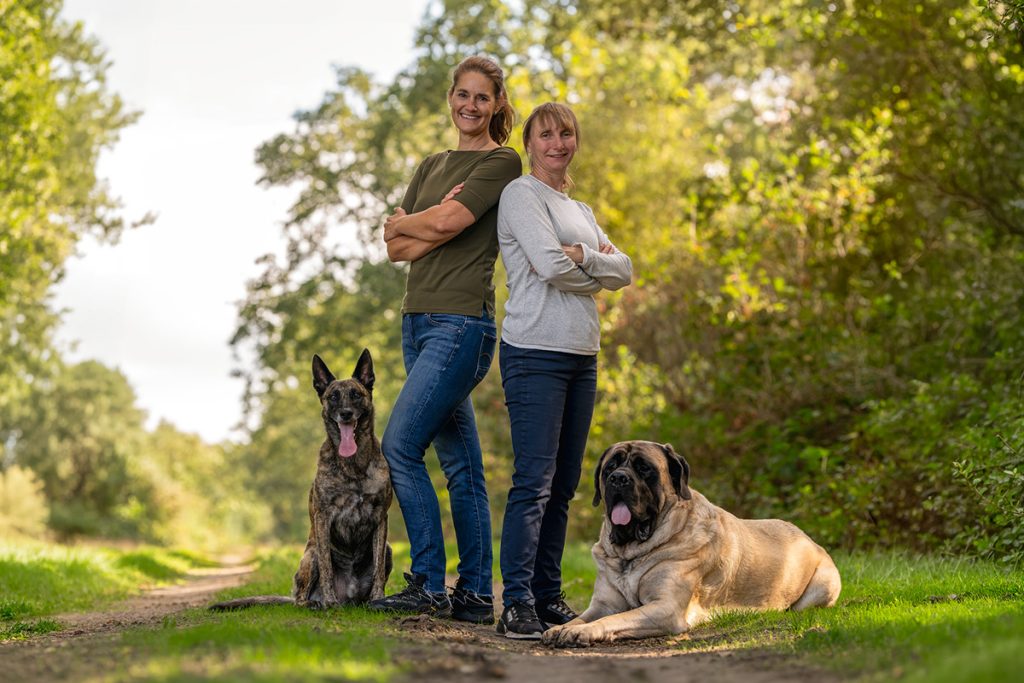 Twee vrouwen met twee honden in een bos