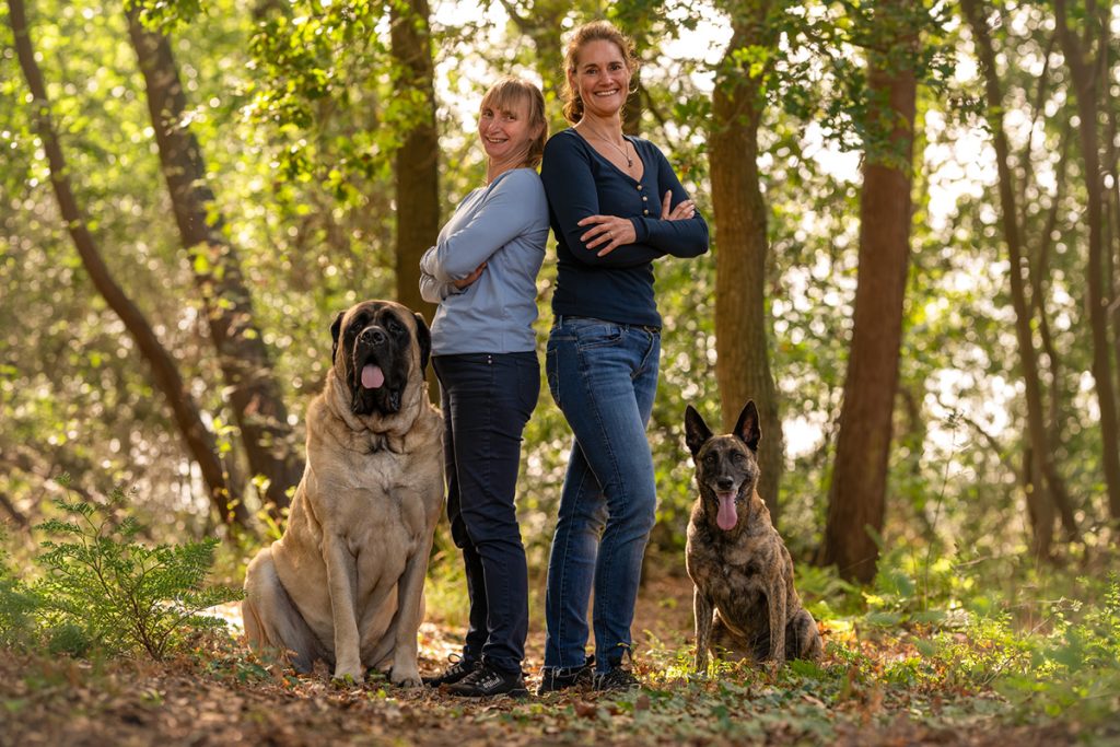 Twee vrouwen met twee honden in een bos