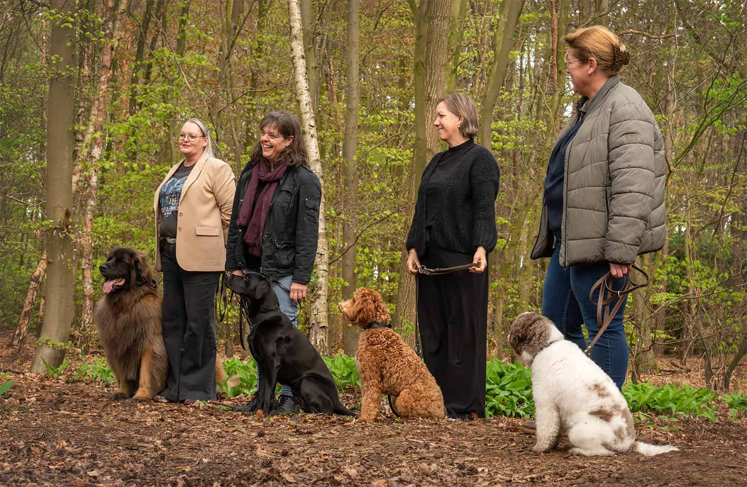 Vier vrouwen met vier honden in een bos